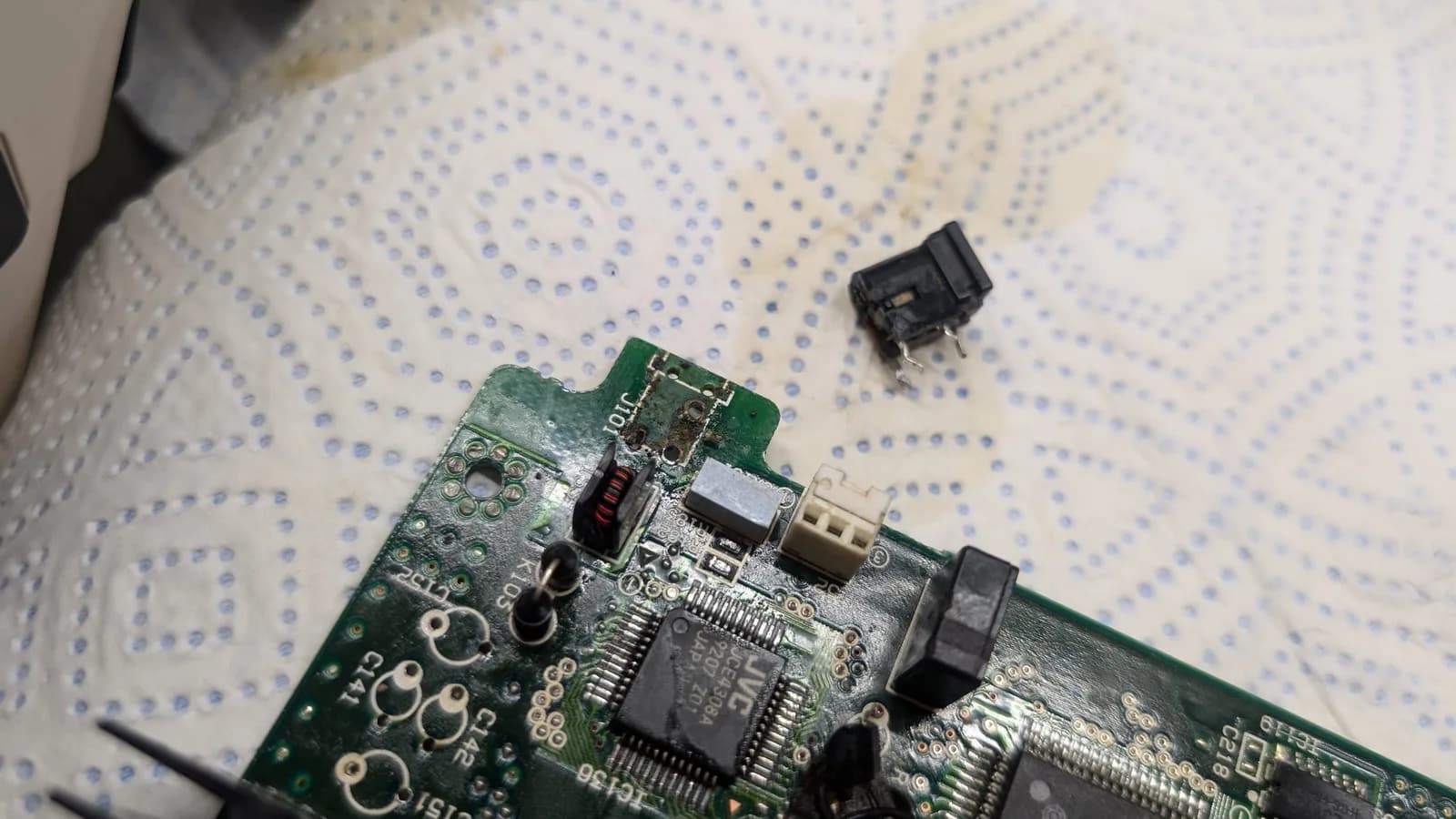 Removed power jack and disconnected switch component beside PCB during corrosion cleaning work on Wondermega board.