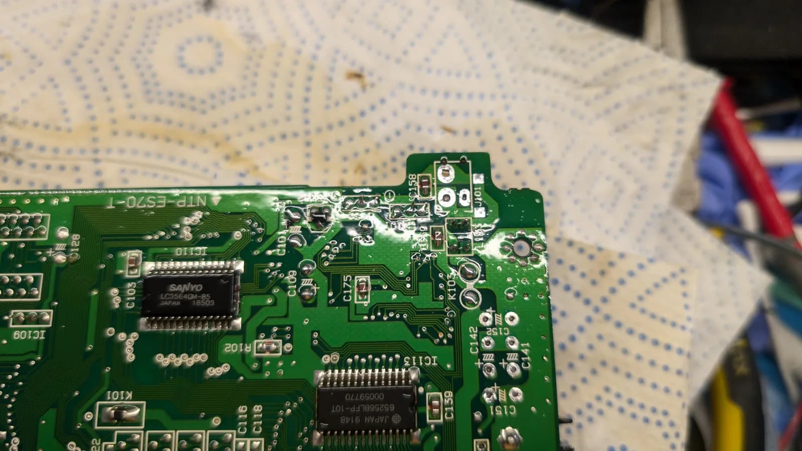 Sega Wondermega PCB with Sanyo IC and corroded power jack removed, showing through-holes needing Deoxit treatment during restoration.