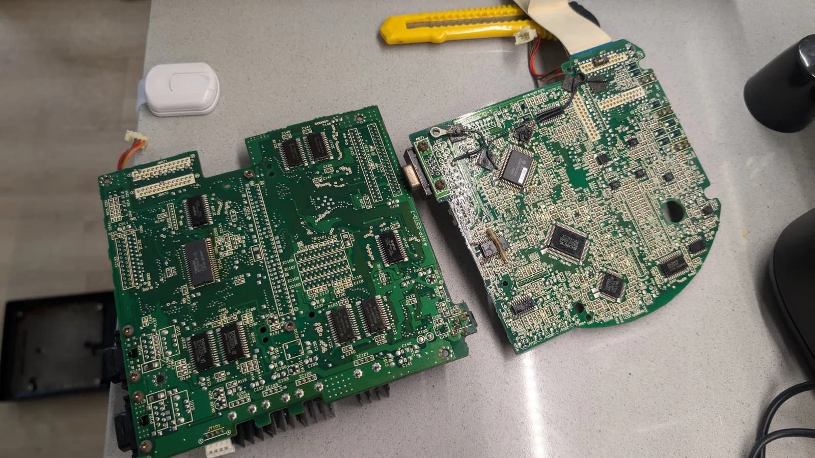 Two Wondermega circuit boards side-by-side after cleanup; left board shows corrosion damage, faded regulator component, and possible broken traces; right board appears in better condition.