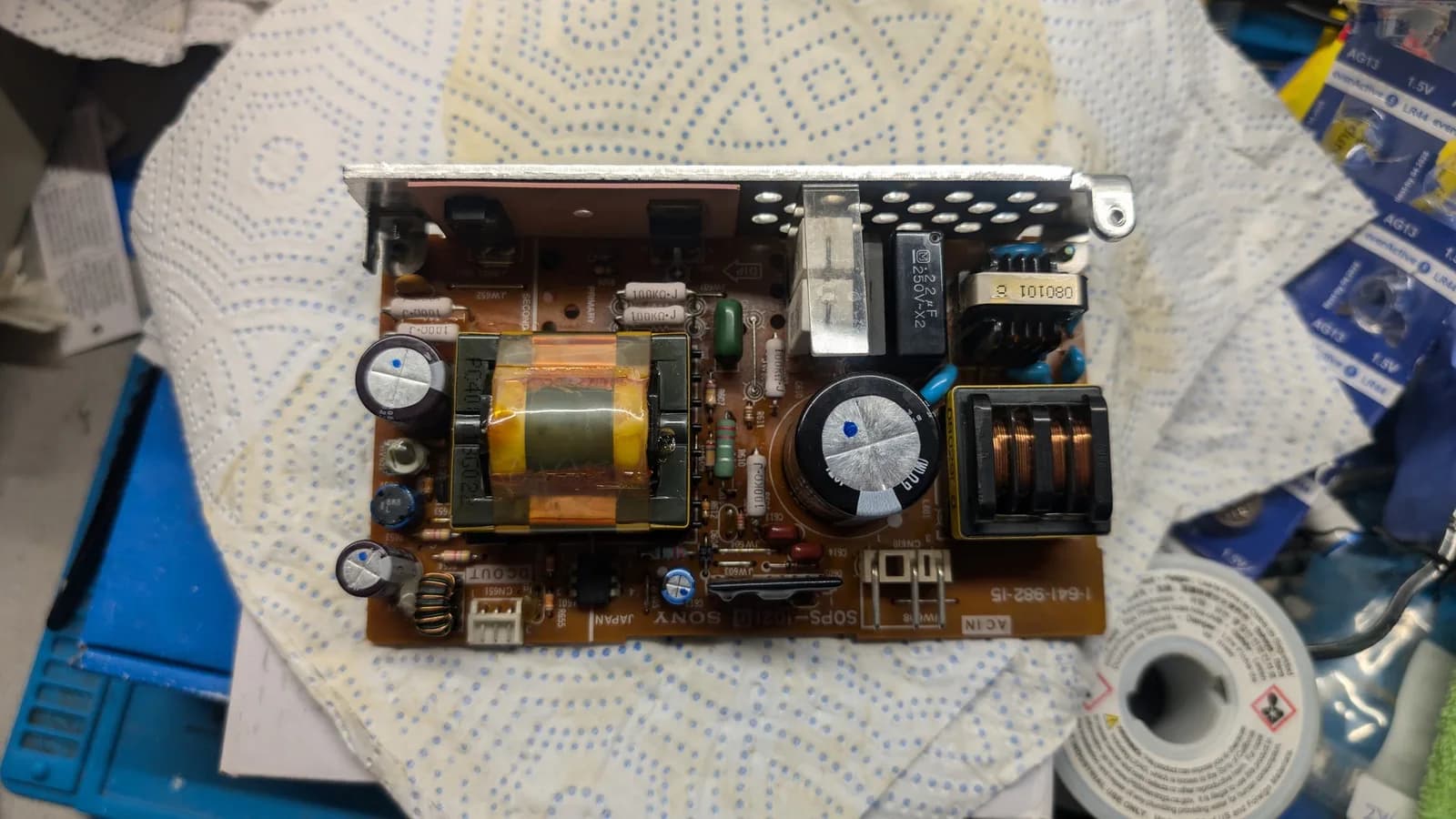Component side of the Sony PVM-9045QD's recapped PSU board (Sony 1-641-982-15): fresh electrolytic capacitors each marked with a blue dot, the tape-wrapped switching transformer, a copper common-mode choke and the black X2 mains capacitor.