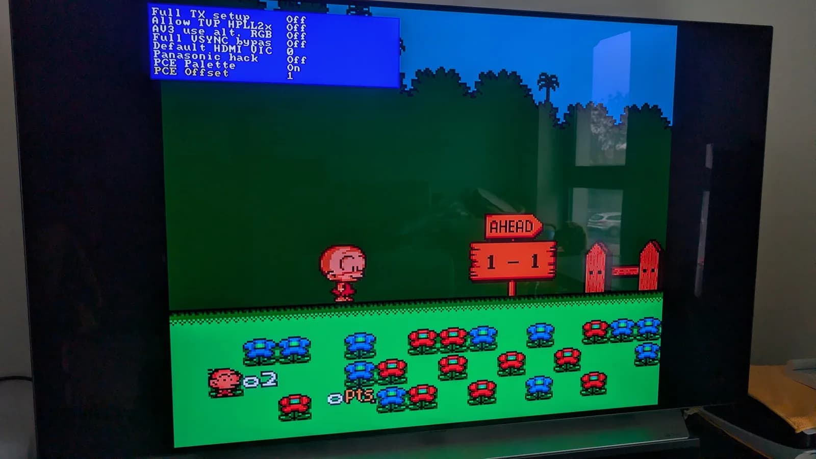 The PC Engine Bonk level running via RGB through the OSSC with the composite-palette emulation ON, on a flat-panel TV, the OSSC settings menu overlaid top-left ('PCE Palette' On, 'PCE Offset' 1).