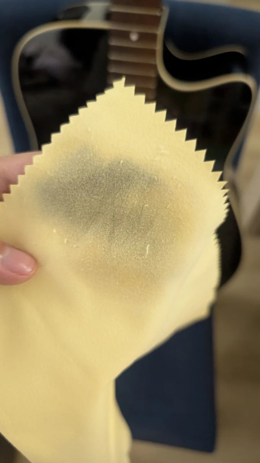 Hands applying lemon oil to Yamaha FX370C fretboard during cleaning and maintenance, showing treated rosewood surface.