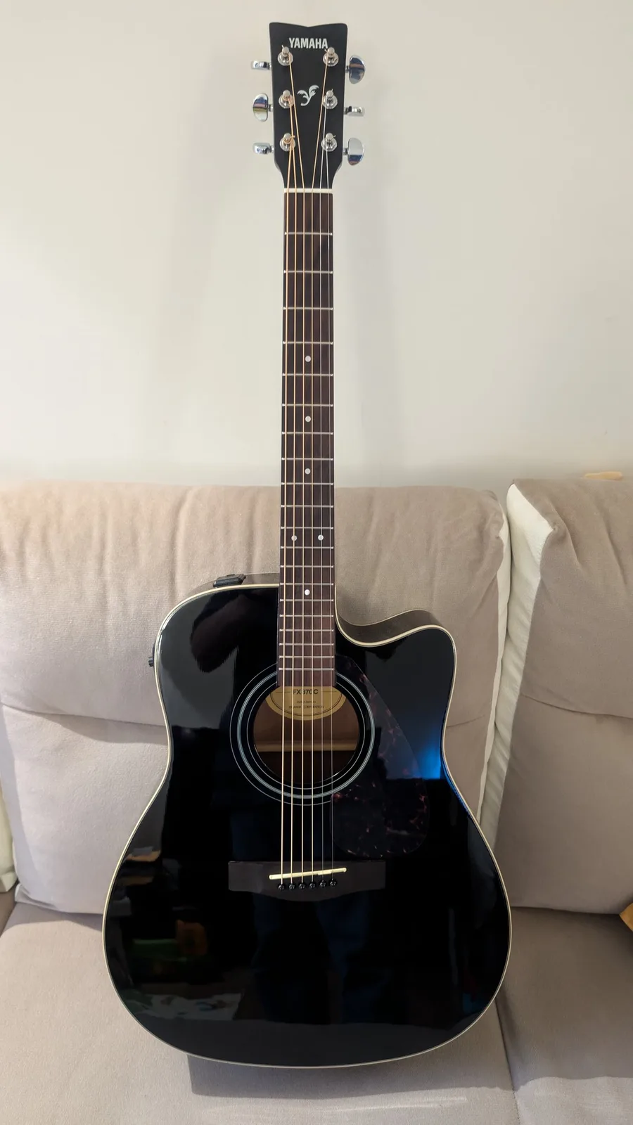 Yamaha FX370C acoustic guitar with black finish, displaying cleaned fretboard, polished body, and new strings after maintenance restoration.