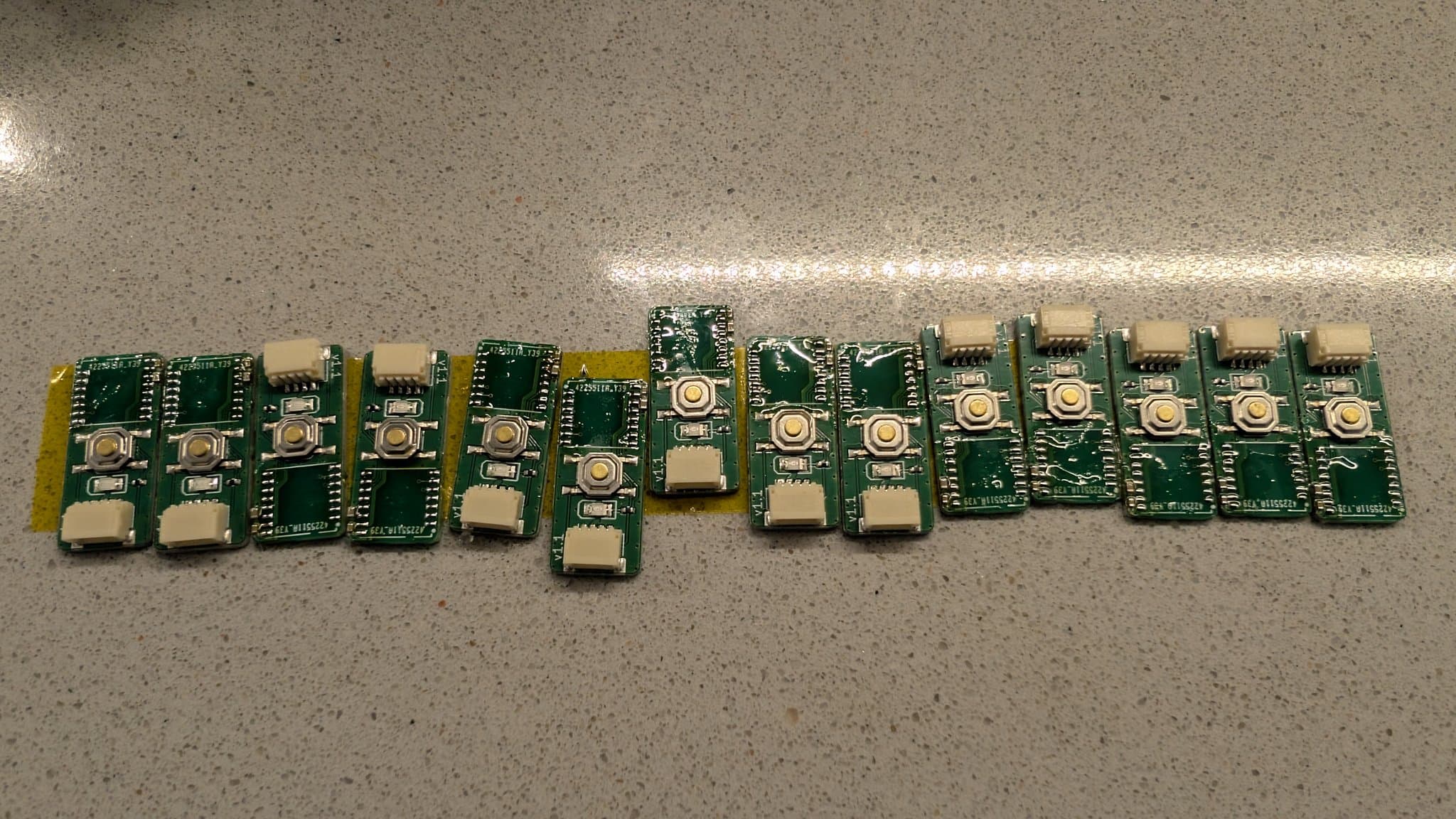 Multiple WavePhoenix PCBs lined up showing tinned pads and hot air soldered components during GameCube WaveBird receiver assembly.