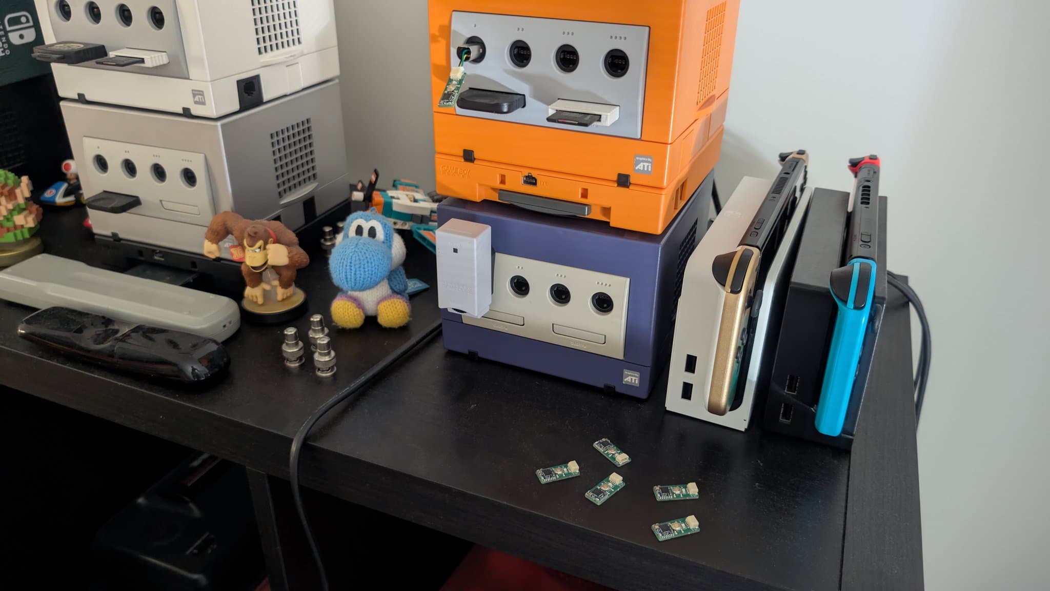 WavePhoenix WaveBird receiver boards completed and tested, displayed with various gaming consoles and controllers on black desk surface.