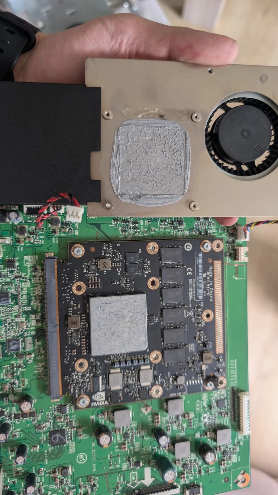 Disassembled Asus PG27UQ monitor showing mainboard and GPU module with crusty thermal paste and dust accumulation on heatsinks.
