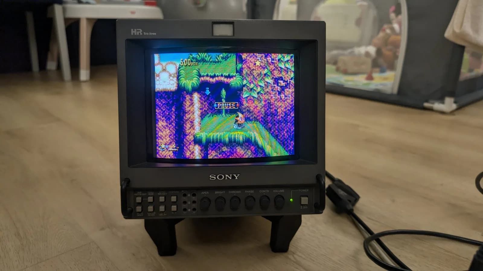 Sony PVM-9045QD on the black BlueShell3D 3D-printed stand, front view, its screen showing a paused game of Ristar on a jungle level.