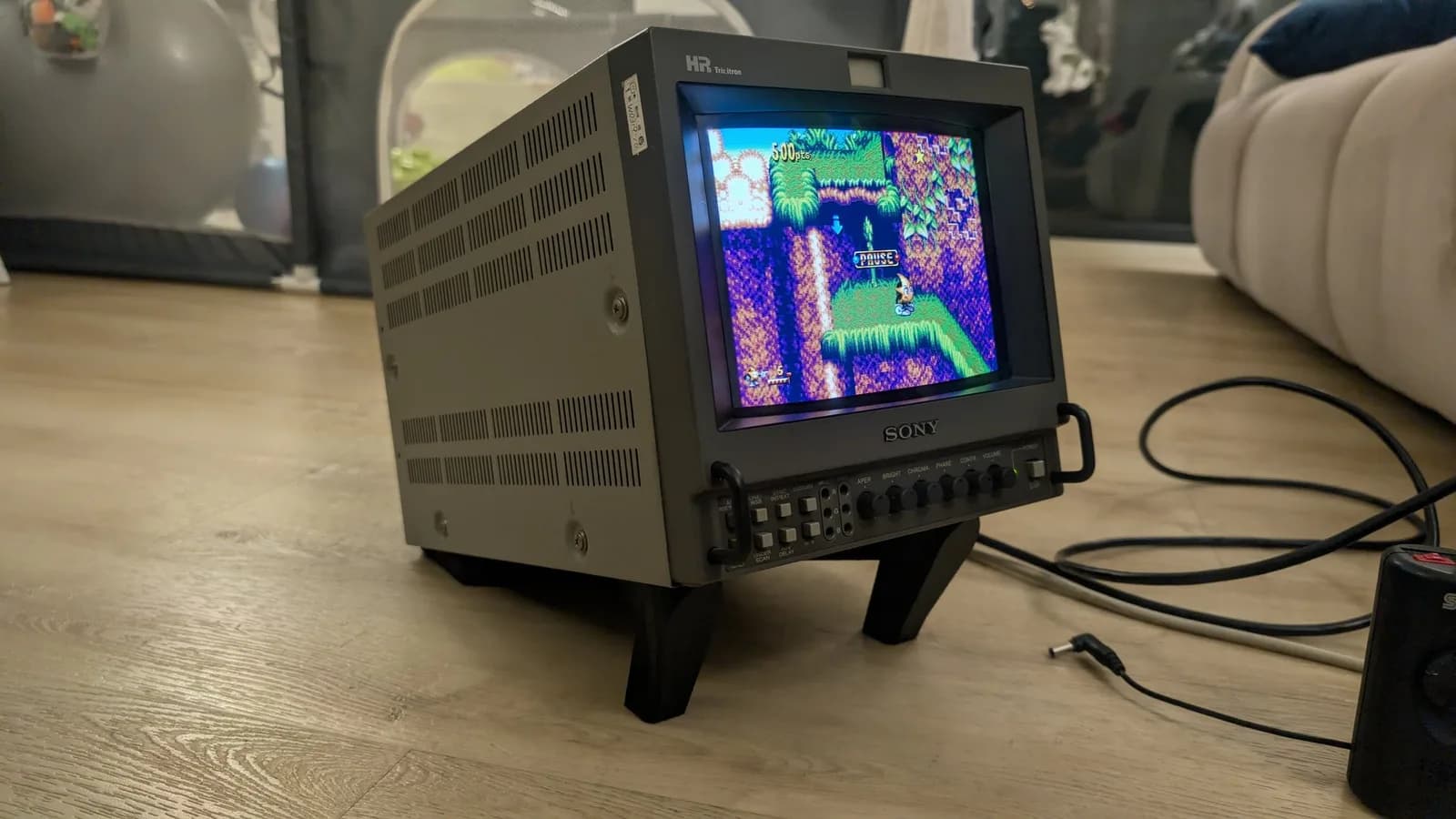 The restored Sony PVM-9045QD on the black BlueShell3D 3D-printed stand, three-quarter view, its screen showing a paused game of Ristar on a jungle level.