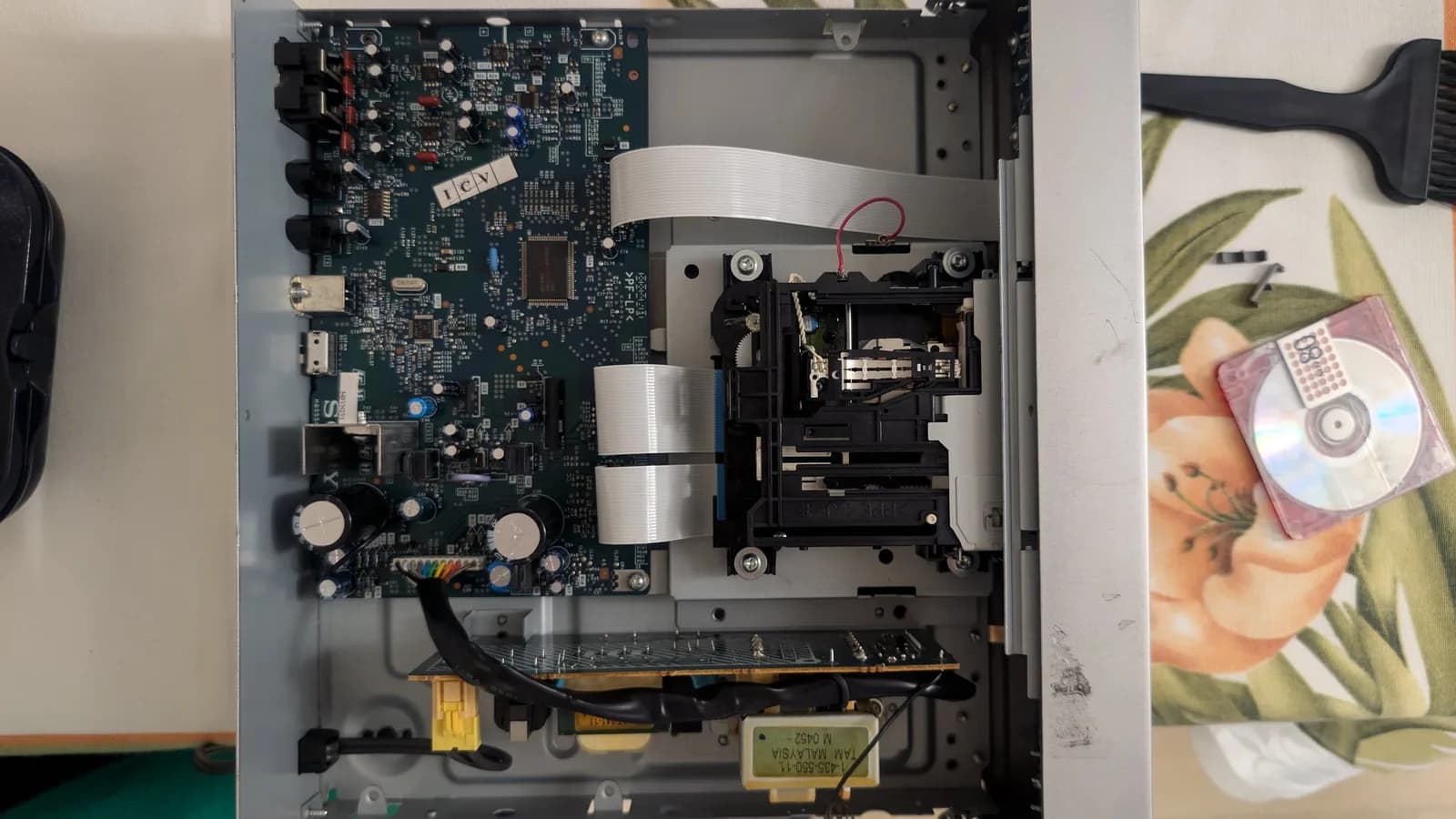 Interior view of Sony MDS-S500 MiniDisc deck with circuit board, disc loading mechanism, and optical drive visible during repair diagnostics.