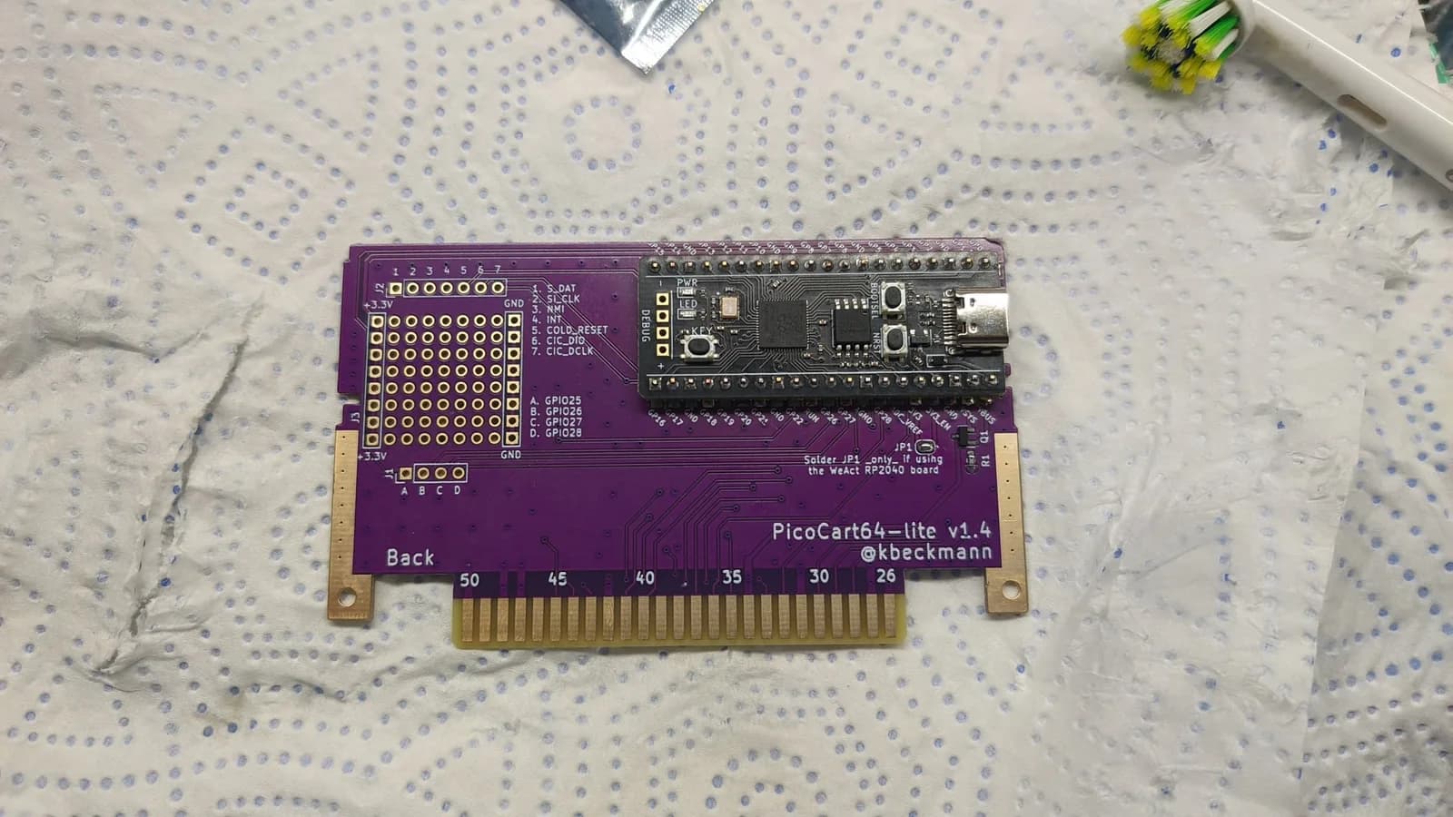 PicoCart64 lite v1.4 PCB back side showing Raspberry Pi Pico microcontroller with 16MB flash and cartridge edge connector pins.