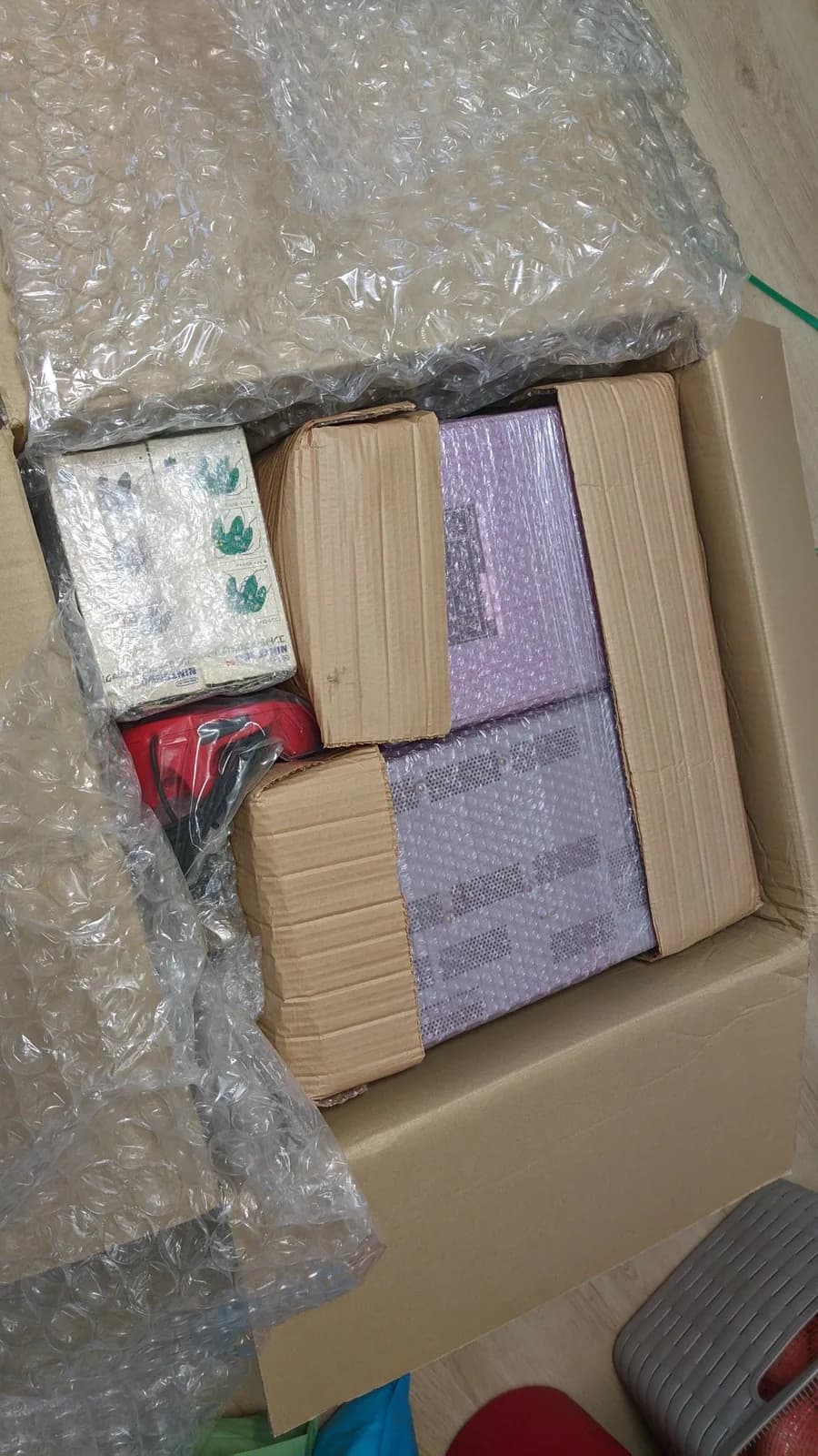 Shipped CRT package opened revealing Victor TM-A101 wrapped in bubble wrap alongside Ikegami monitor, both damaged in transit due to inadequate protective packaging.