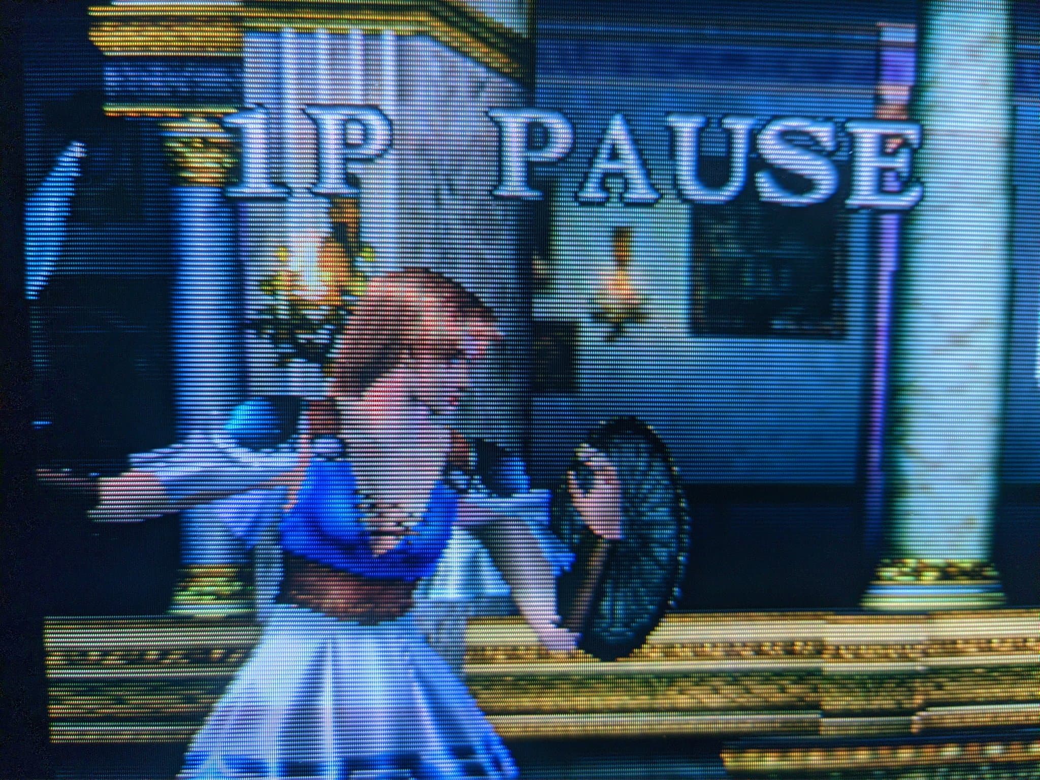 Close-up of a Sony Trinitron CRT (aperture-grille phosphor) running Soul Calibur, with the 1P PAUSE overlay and a fighter visible.