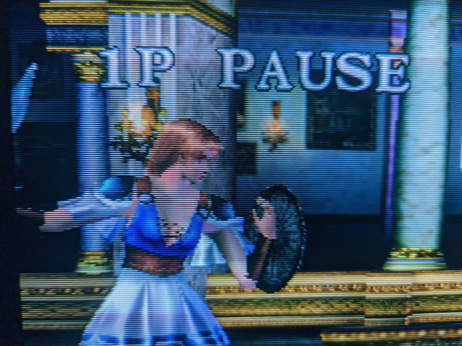 Close-up of a Sony Trinitron CRT (aperture-grille phosphor) running Soul Calibur, with the 1P PAUSE overlay and a fighter visible.