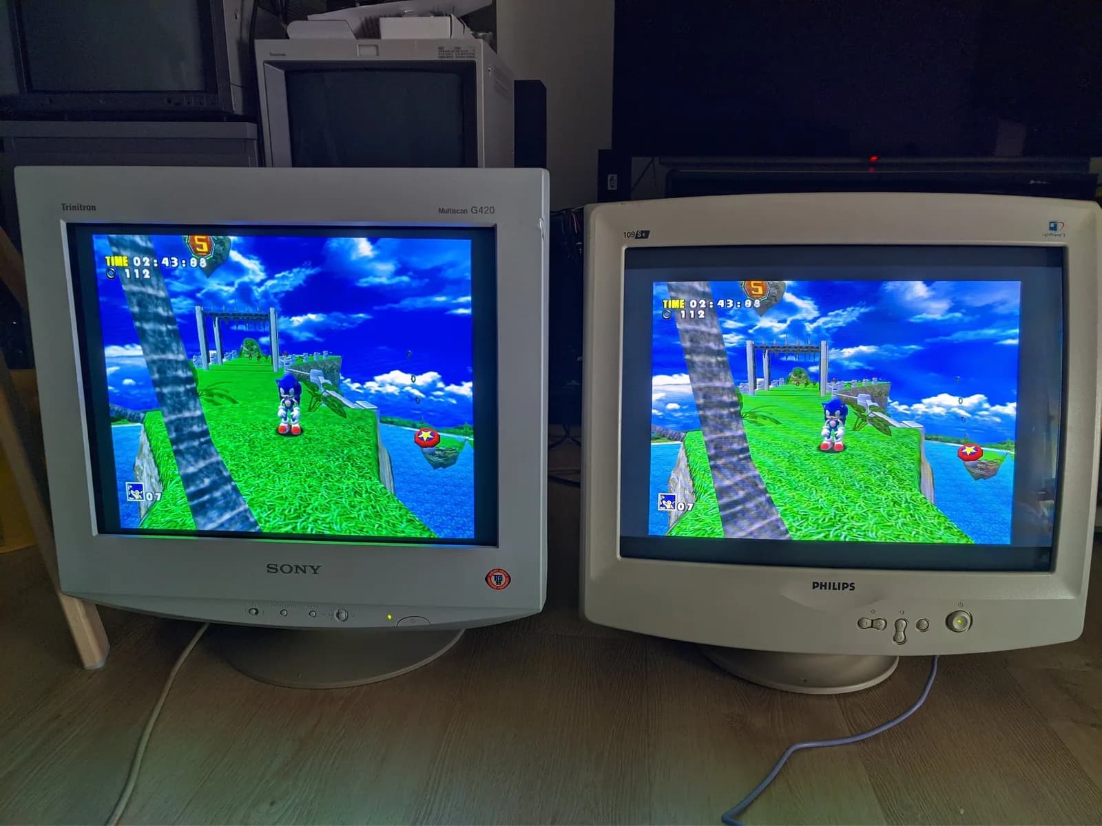 The Sony CPD-G420 (left) and Philips 109S4 (right) side by side, both fed the same Sonic Adventure signal from one Dreamcast (Sonic on a grassy clifftop, TIME 02:43, 112 rings).