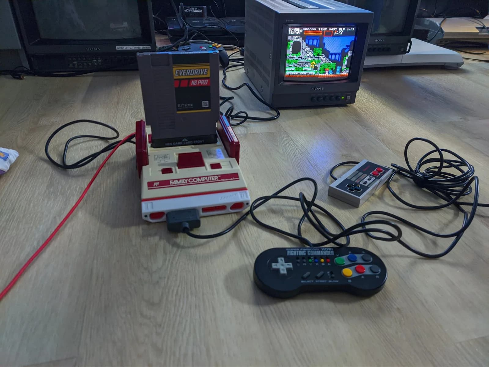 Famicom NES controller adapter connected to original Family Computer console with Fighting Commander controller, displaying Castlevania gameplay on Sony CRT monitor.