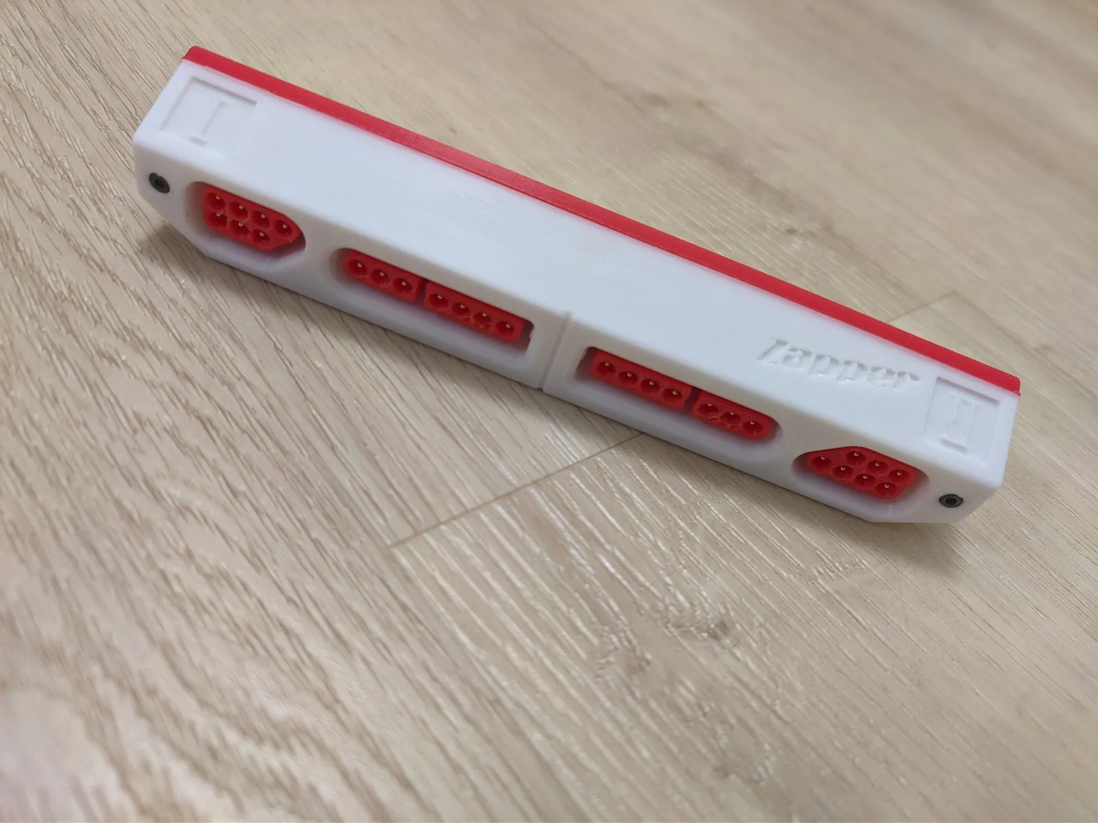 Famicoun NES controller adapter with red LED indicator lights and white housing, displayed on wooden surface.