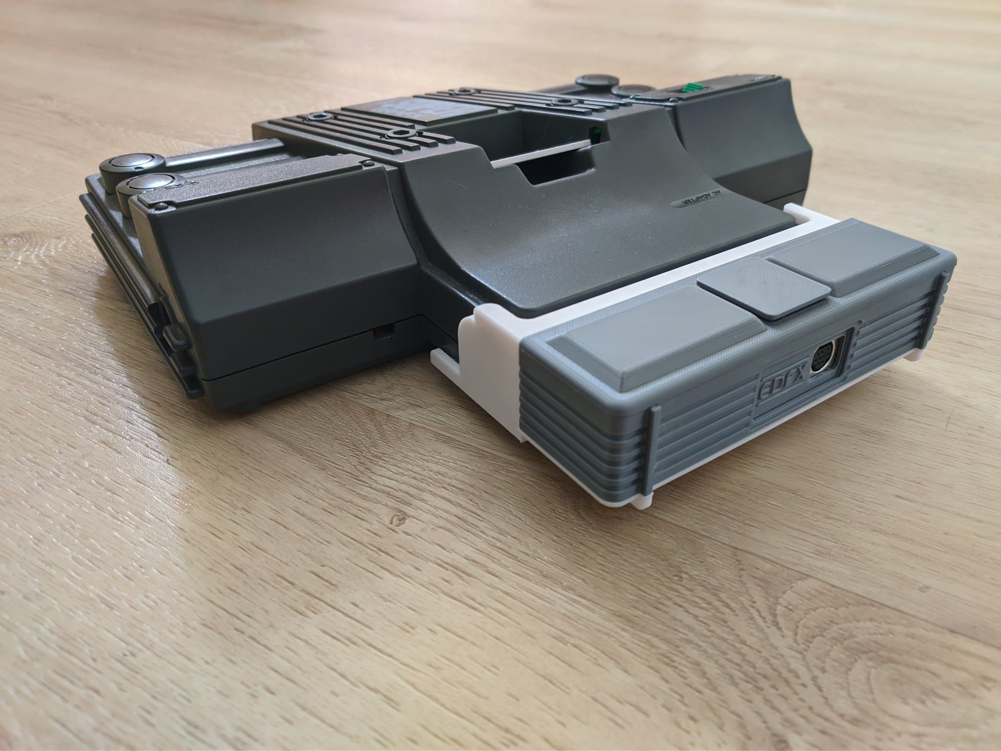 Refurbished NEC PC Engine SuperGrafx with the EDFX (in its 3D-printed mini-IFU shell) connected directly to its Ext Bus port, on a wooden surface.