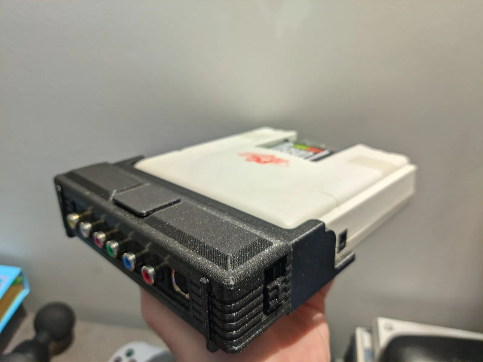 The PC Engine AV adapter in a PointerFunction 3D-printed enclosure, its RCA outputs on the black housing (composite is carried over an RCA jack), the HuCard slot above.