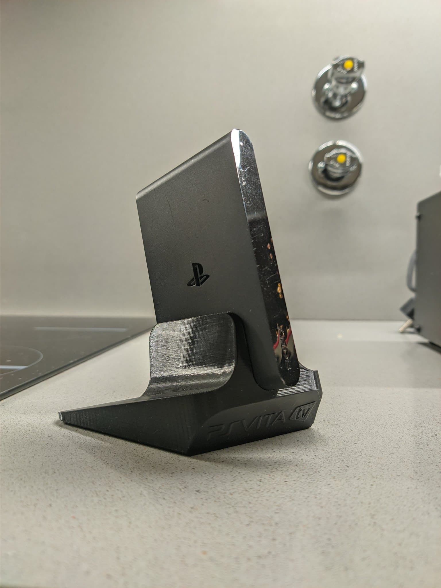 Black PS Vita TV on Jeff Chen 3D-printed stand, cleaned and ready for use after CFW installation and restoration.