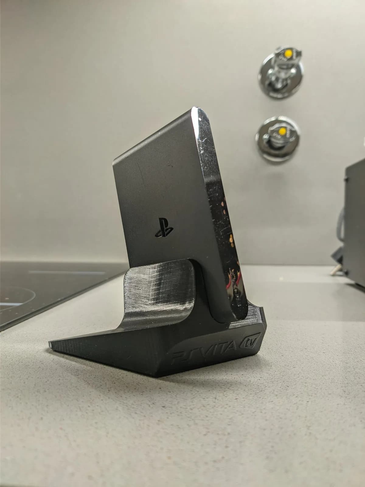 Black PS Vita TV on Jeff Chen 3D-printed stand, cleaned and ready for use after CFW installation and restoration.