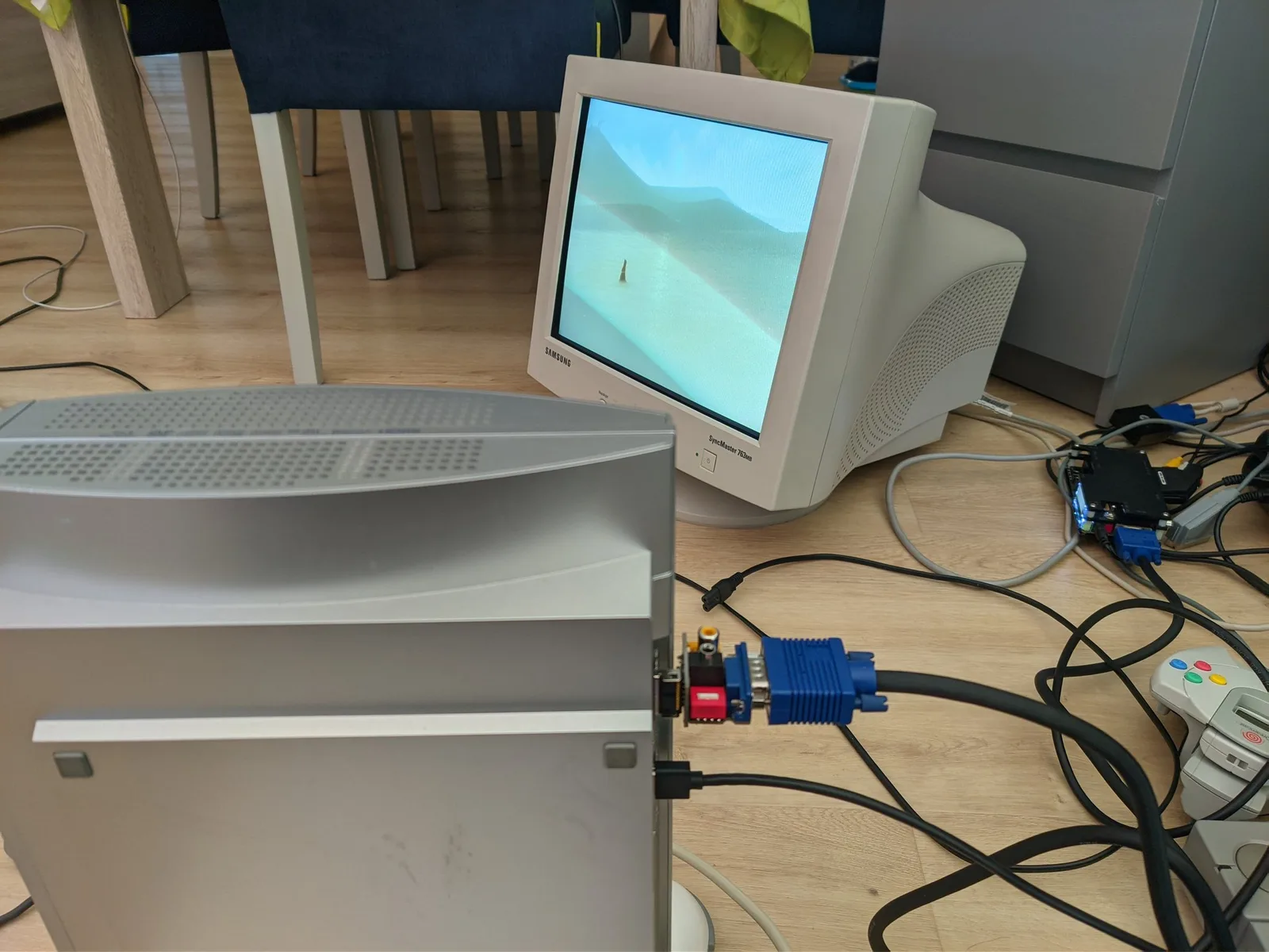 A silver PlayStation 3 (Metal Gear Solid 4 edition) running Journey, its video taken by the Jeff Chen VGA dongle into an OSSC Classic and then through an HP HDMI-to-VGA adapter to the Samsung SyncMaster CRT; cables run across the wooden floor.