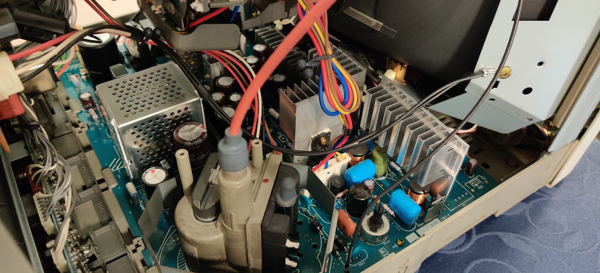 Interior of Sony PVM-14L2 showing clean PCB, capacitors in good condition, power supply components, and colorful wiring harness.