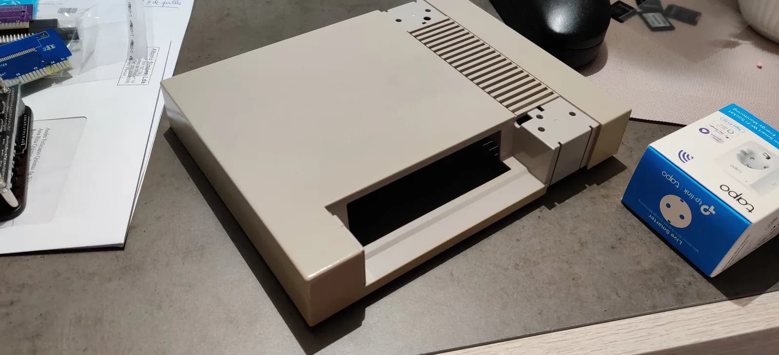 NES top shell, alongside retrobriting supplies and blue storage packaging on workbench.