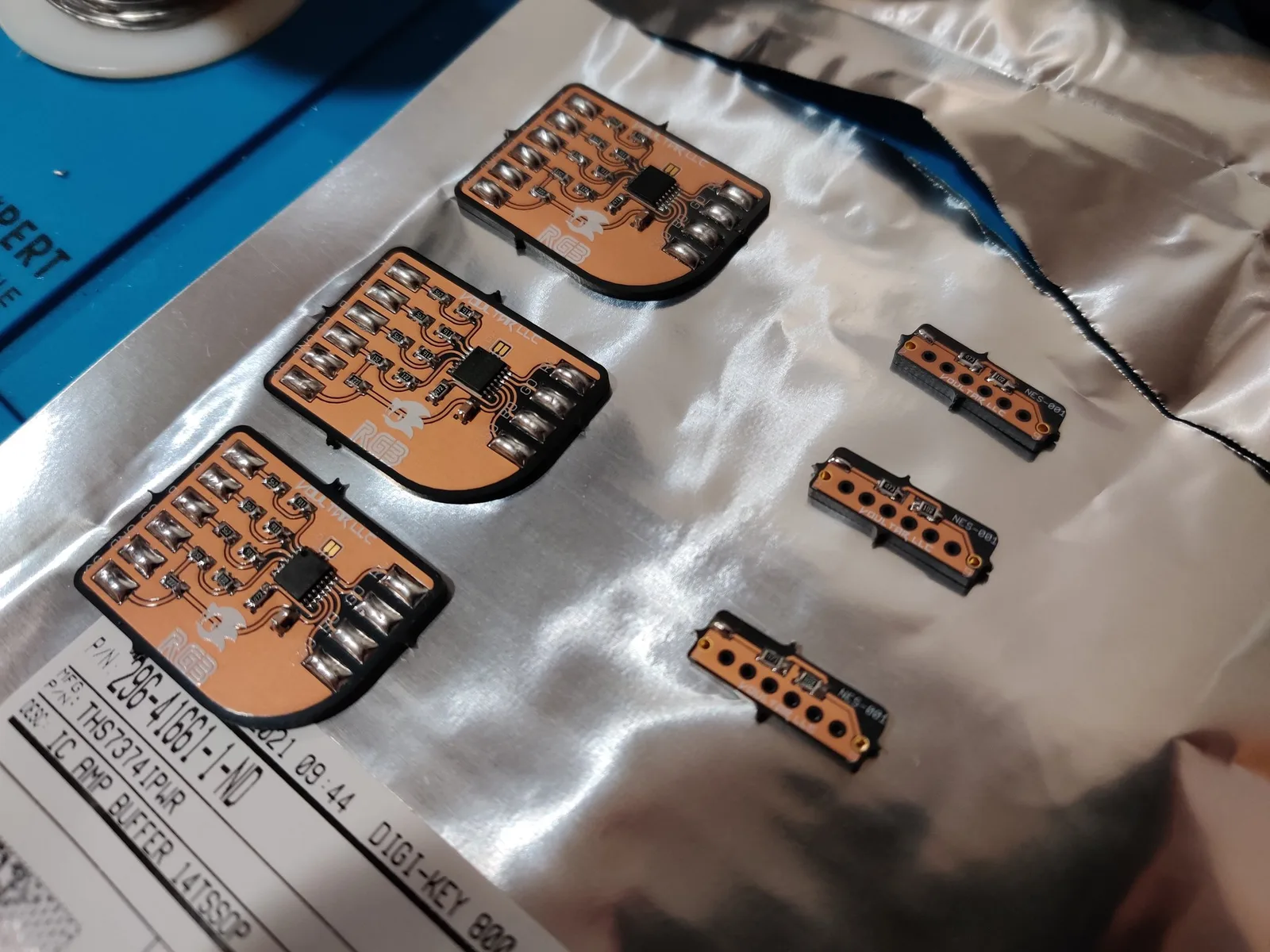 Three Voultar MD RGB bypass boards and three NES expansion audio boards on anti-static mat, first soldering project with populated components visible.
