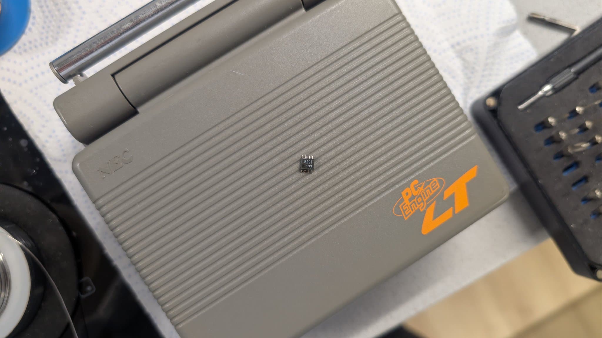 Removed 8-pin 6.5V regulator (M5291FP, marked 5291) resting on the closed NEC PC Engine LT case during the repair.