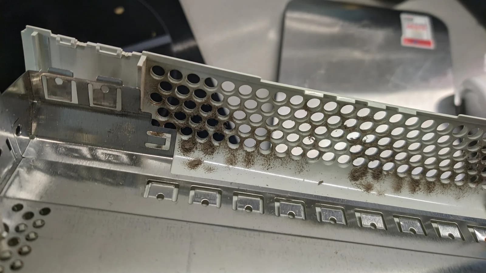 The exhaust side of the Xbox 360's outer shell, caked in dust.