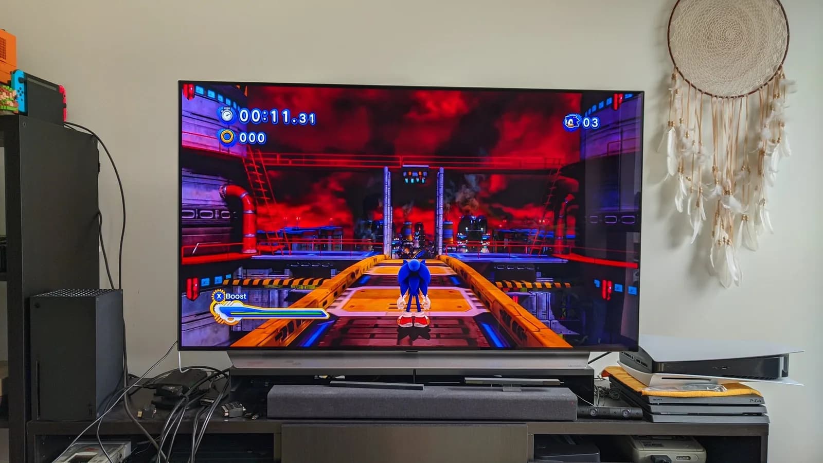 Sonic Generations running on a large flat-screen TV, the post-repair test after the Xbox 360 S PSU recap and joint reflow: modern Sonic on an orange industrial walkway under a red sky, with a timer and boost meter on screen.