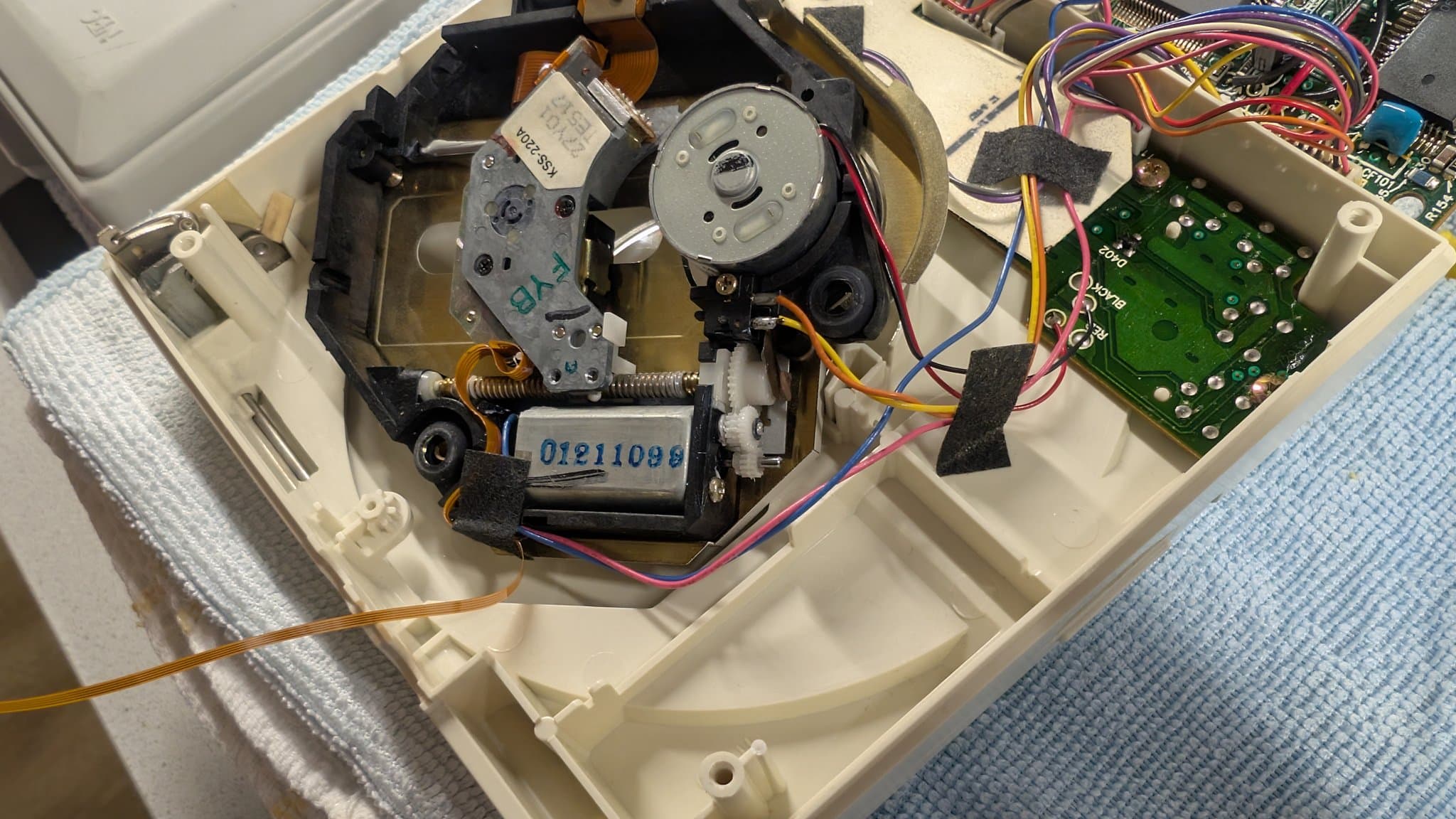 PC Engine CD-ROM2 interior with the motor, laser, green control board and wiring, now with the new 3D-printed gear installed on the shaft and freshly lubed.