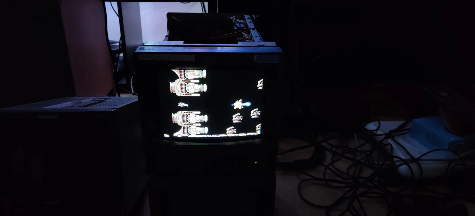Reassembled Sony PVM-9041Q running an R-Type port homebrew demo (built with SGDK) after the PSU recap and trimmer-pot swap, scanlines visible, a Sony Multiformat monitor beside it.