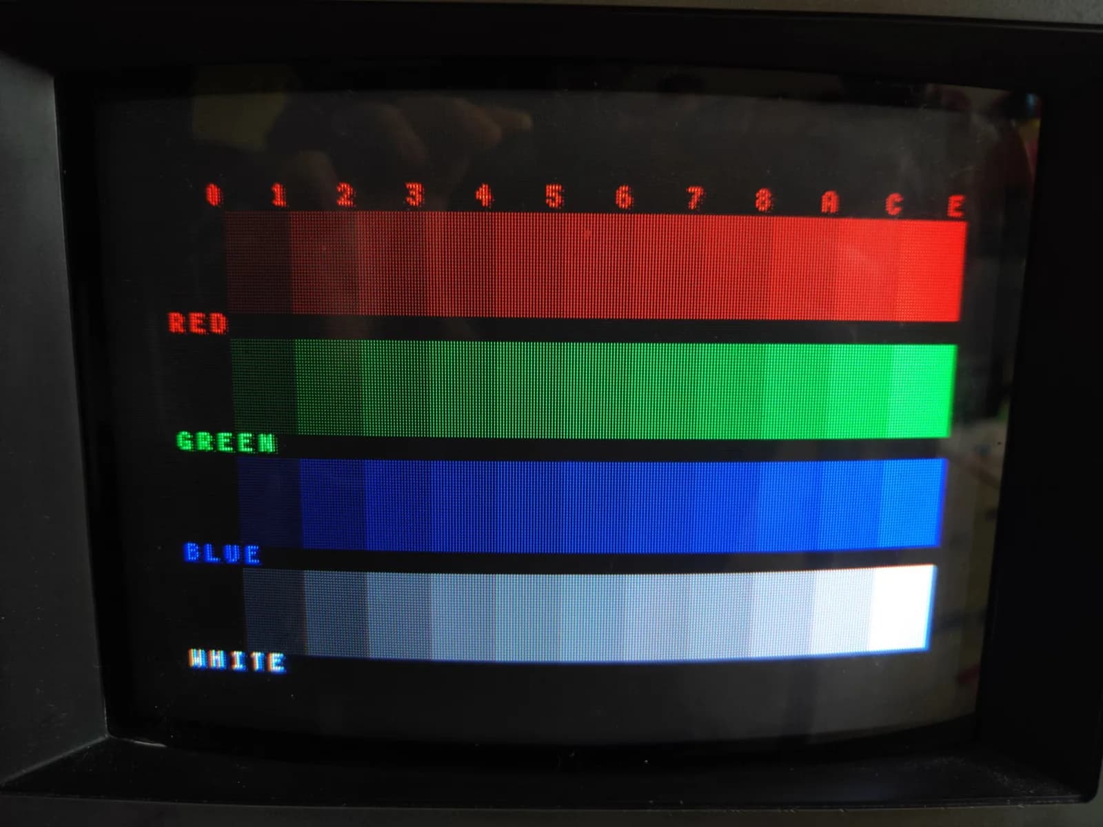 Sony PVM-9041Q on the bench for its incoming assessment, displaying a colour-bar test pattern: red, green, blue and white gradient bars over a 0-to-E greyscale step scale.
