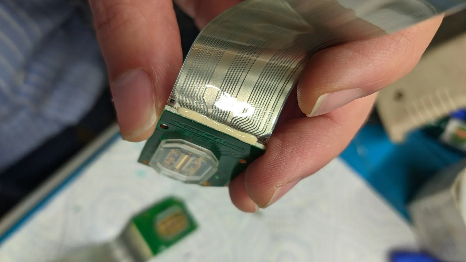 Peeling separated ribbon cable from LED array PCB during Virtual Boy refurbishment, showing delicate adhesive removal process.