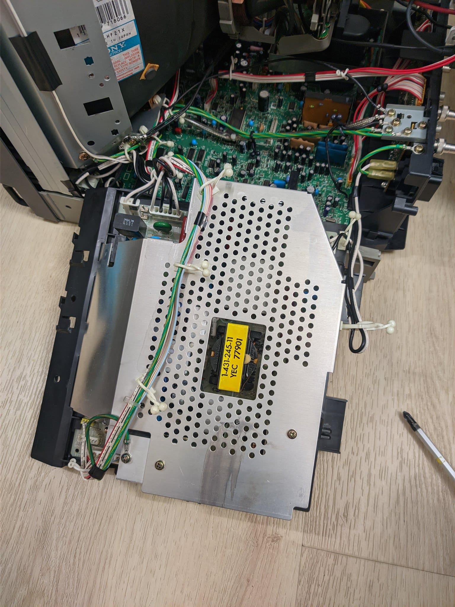 Sony PVM-14M4J power supply with recapped components, yellow transformer visible, green and red wiring, metal chassis with ventilation holes.