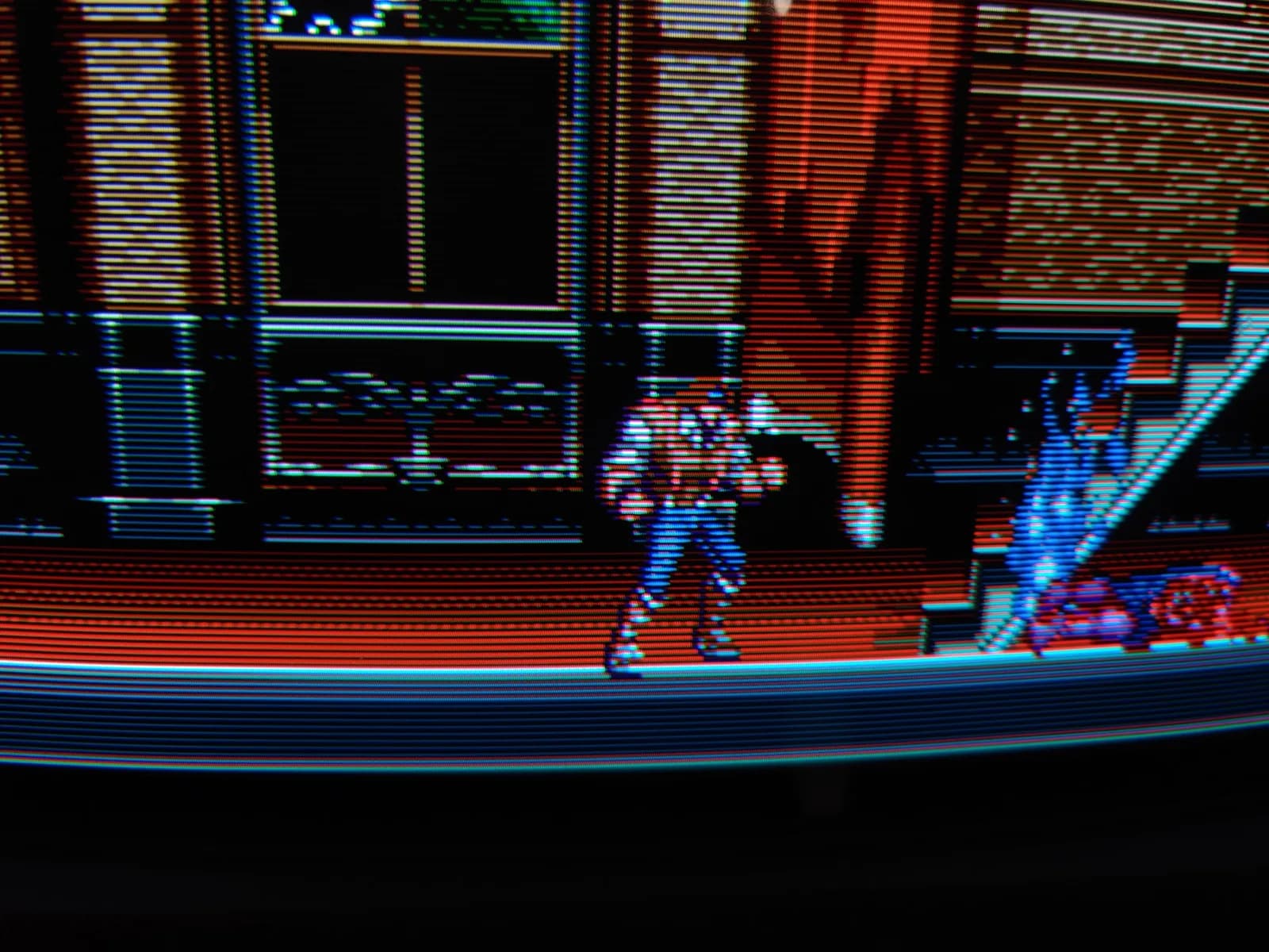 Extreme close-up of Castlevania Bloodlines on the Sony BVM-D14H1E, the whip hero's sprite beside a staircase with red steps and light-blue sides, the CRT's fine scanlines and RGB phosphor stripes clearly visible.