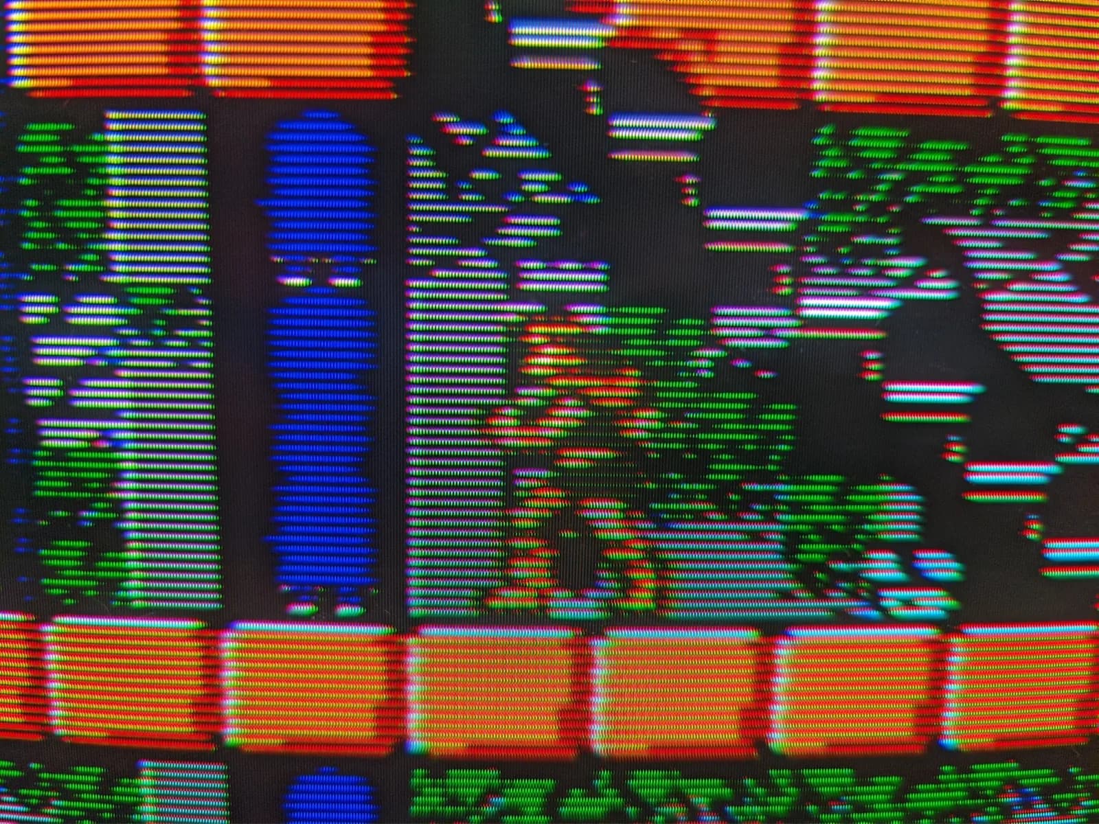 Extreme close-up of the Sony BVM-D14H1E screen, the RGB phosphor stripes and scanlines resolving a Castlevania III scene (orange brick platforms and a blue figure), run from a Famicom over composite through the BKM-127W.