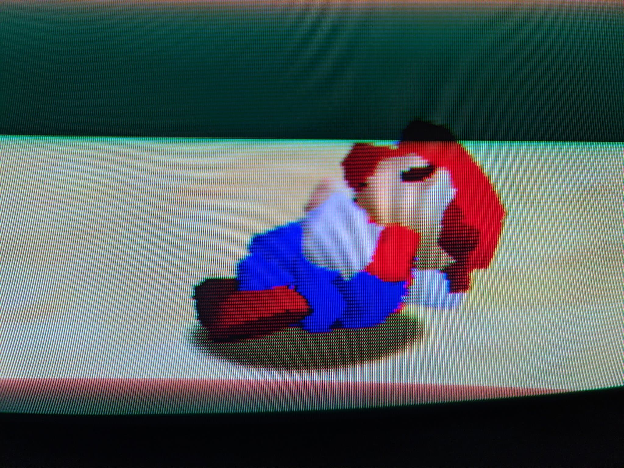 Super Mario 64 with Mario in his idle, sleeping pose on a wood-grain floor, shown on a restored broadcast CRT.