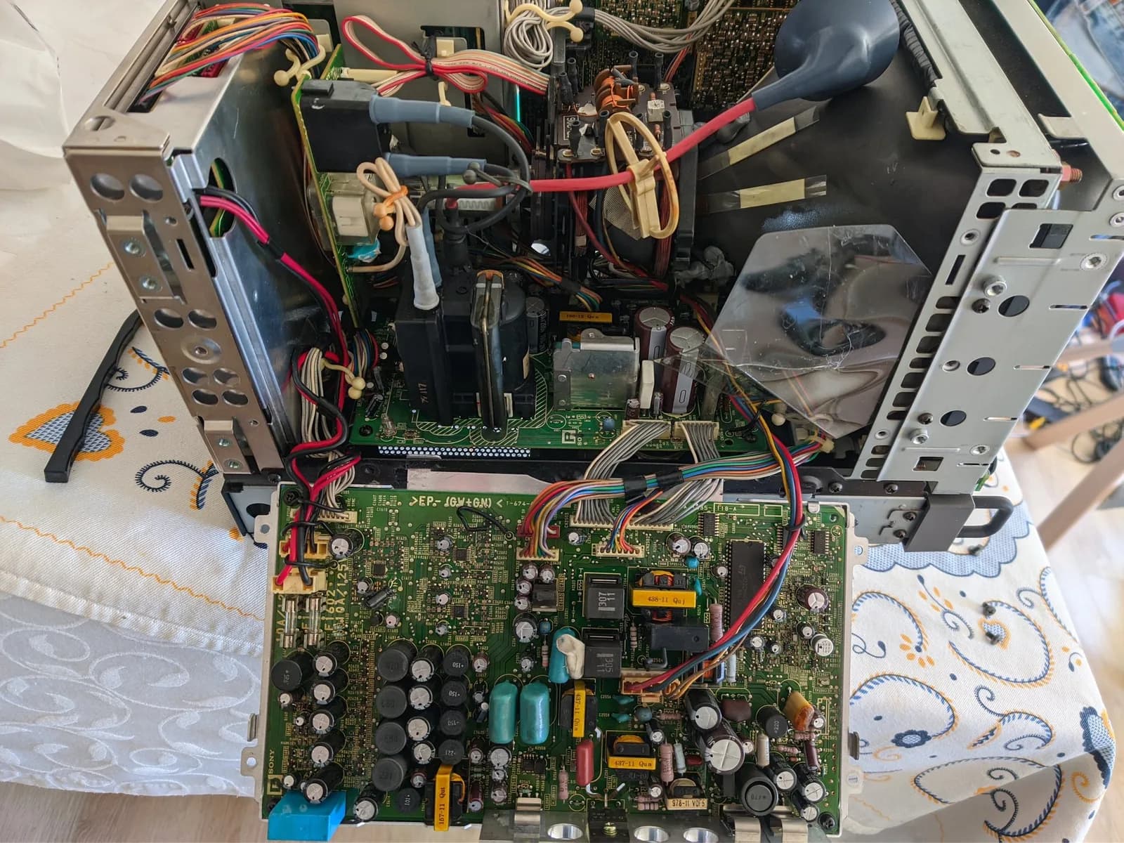 Interior of the opened Sony BVM-D9H5J with the D board in its service position, its capacitors all marked with paint dots (a sign of an earlier service), a multicoloured wiring harness alongside, and the anode cap still not fitted to the tube.