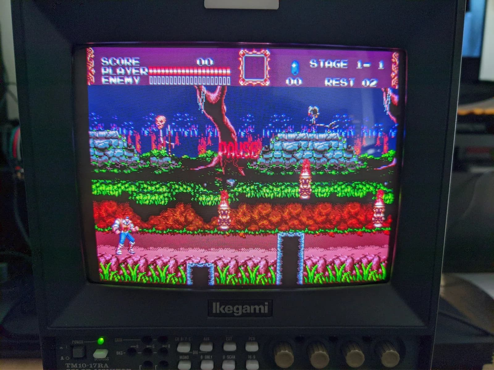 Ikegami TM10-17RA CRT showing Vampire Killer (Castlevania: Bloodlines), John Morris in blue on the ground in a flame-lit forest, with 'STAGE 1-1' on screen, during testing.