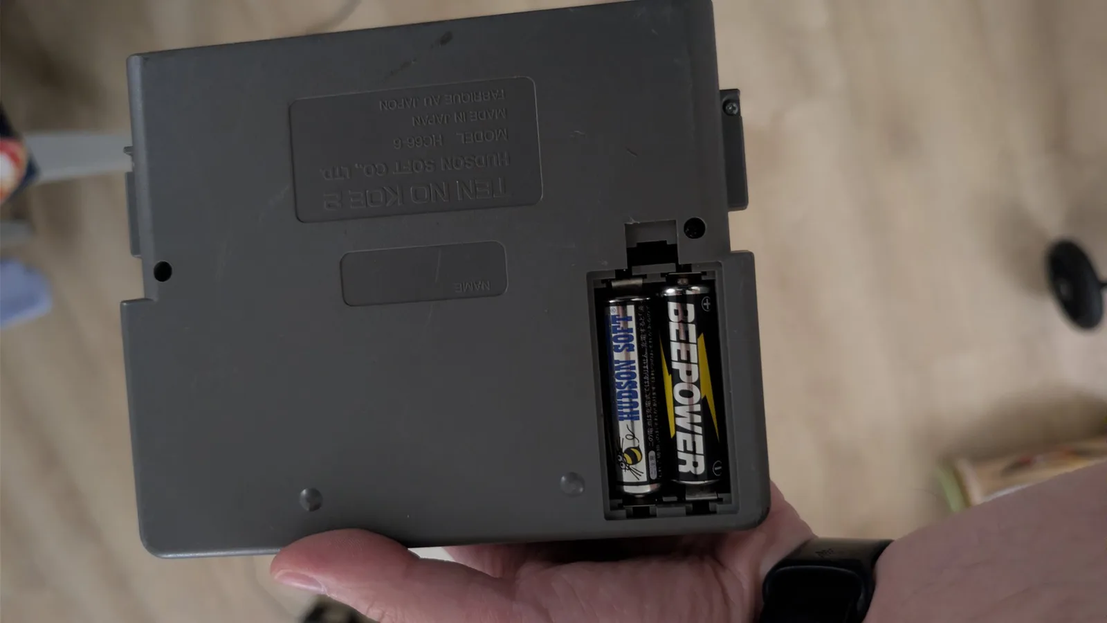 NEC Ten No Koe 2 battery compartment showing original Hudson Soft branded batteries after removal during recap repair.