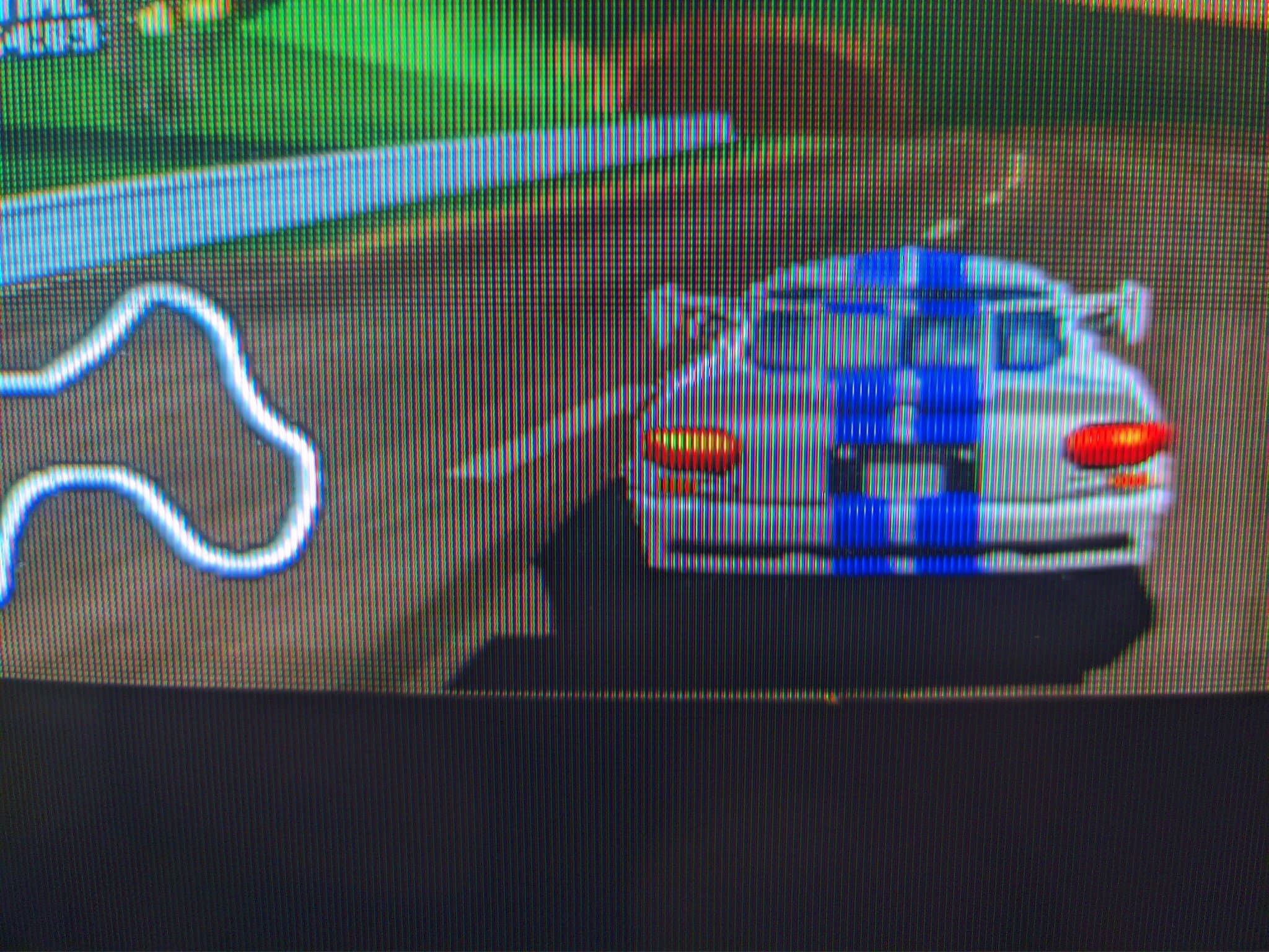 Three Sony PVM-9040 CRT monitors displaying N64 World Driver Championship gameplay in hi-res mode, showing blue race car with red details on track.