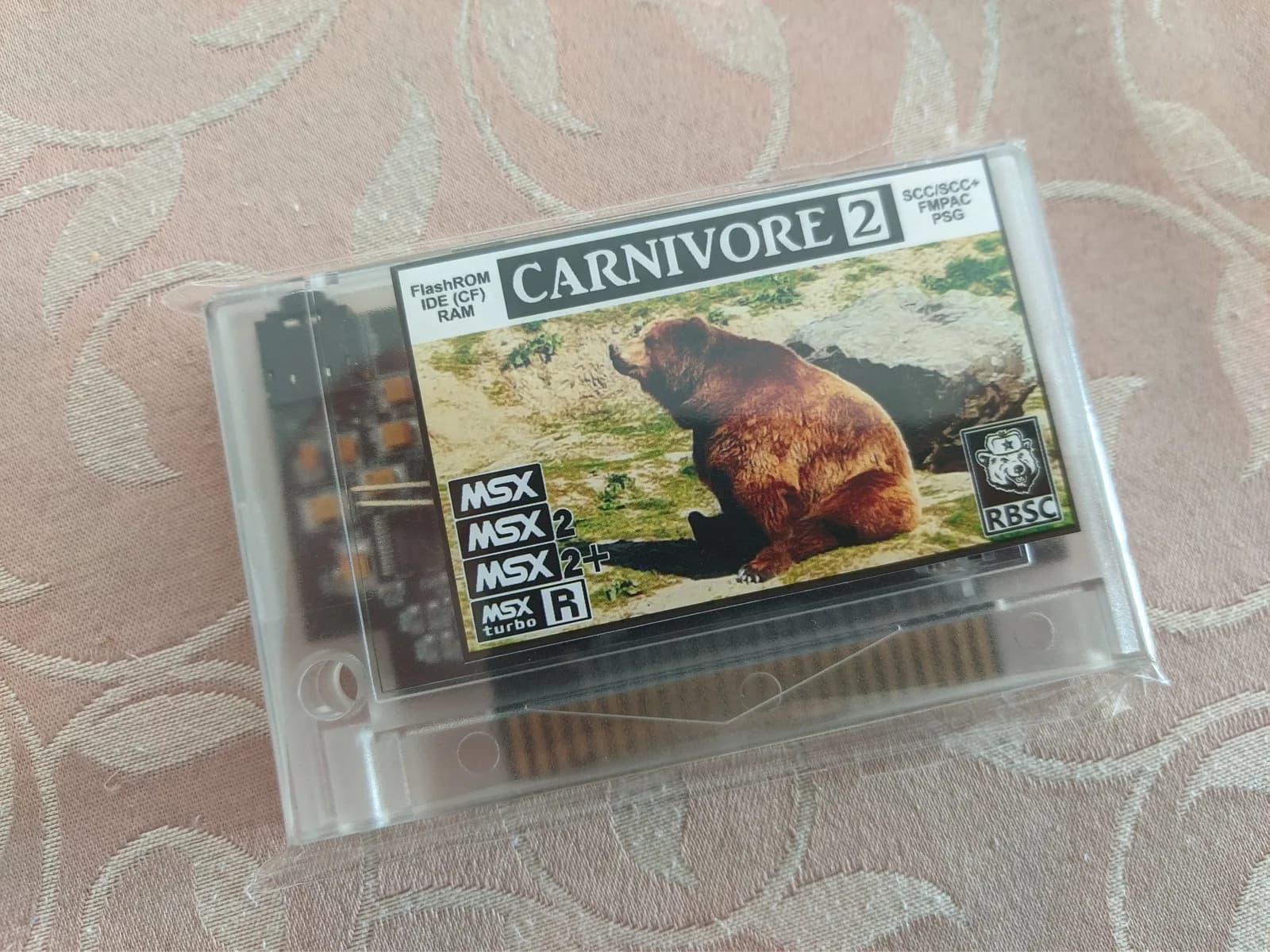 Carnivore 2 flashcart for MSX systems in clear plastic case, showing compatible MSX/MSX2/MSX2+/MSX turbo R labels and RBSC branding with game screenshot.