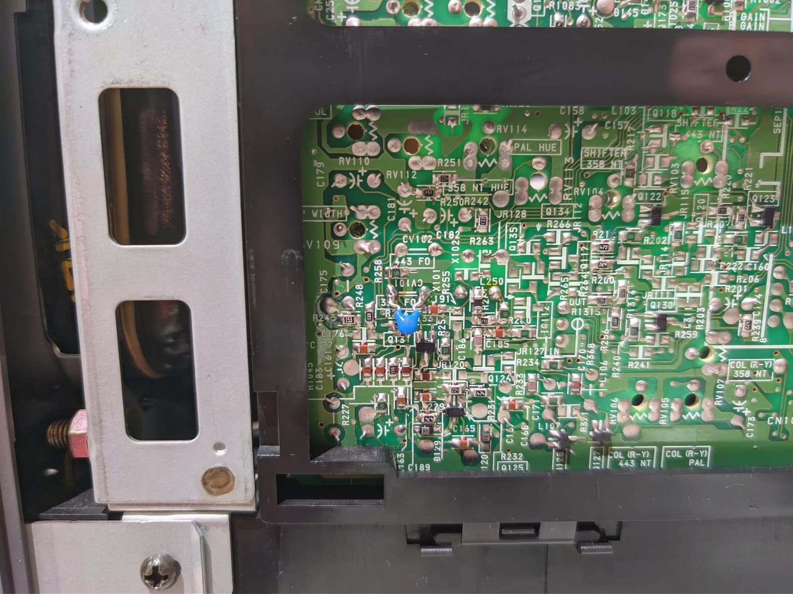 Close-up of PVM-9040 circuit board showing replaced trim potentiometers and ceramic capacitor installation during color restoration repair work.