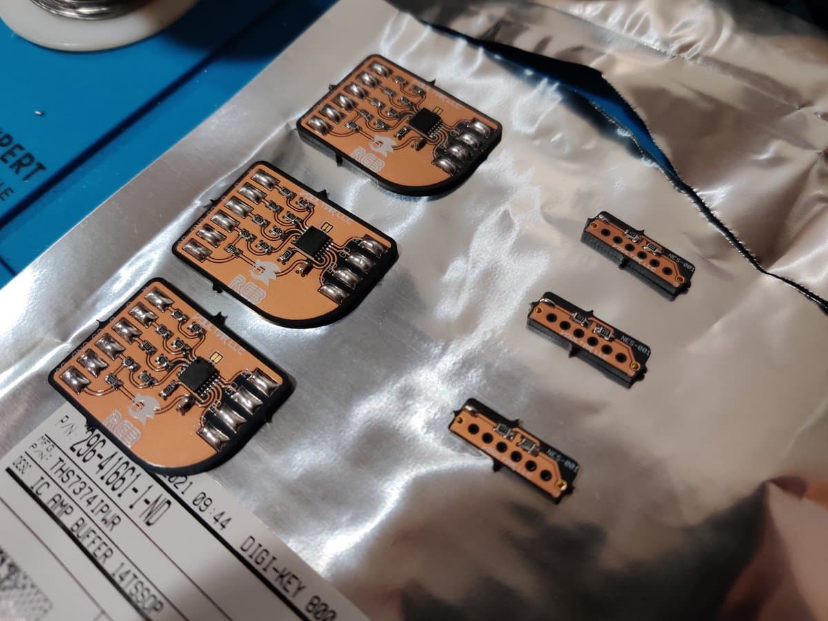 Three Voultar MD RGB bypass boards and three NES expansion audio boards on anti-static mat, first soldering project with populated components visible.