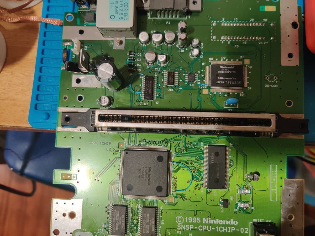 SNES 1-chip motherboard with lifted CPU pins, SCIC chip installation, and LED mod work in progress during 50/60Hz modification.