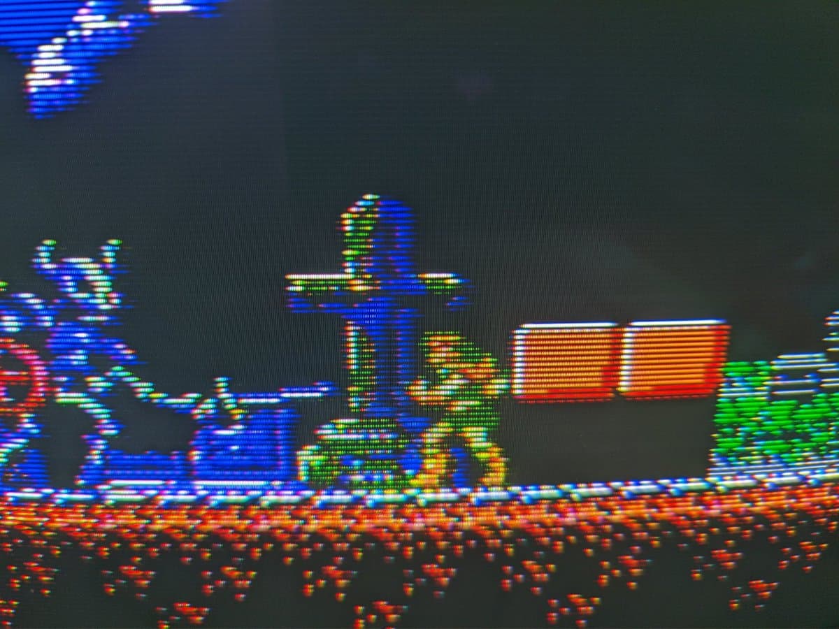 Famicom running Castlevania 3 gameplay with composite mod board installed, displaying colorful 8-bit sprite graphics and level scenery on screen.
