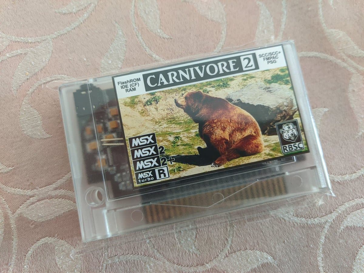Carnivore 2 flashcart for MSX systems in clear plastic case, showing compatible MSX/MSX2/MSX2+/MSX turbo R labels and RBSC branding with game screenshot.