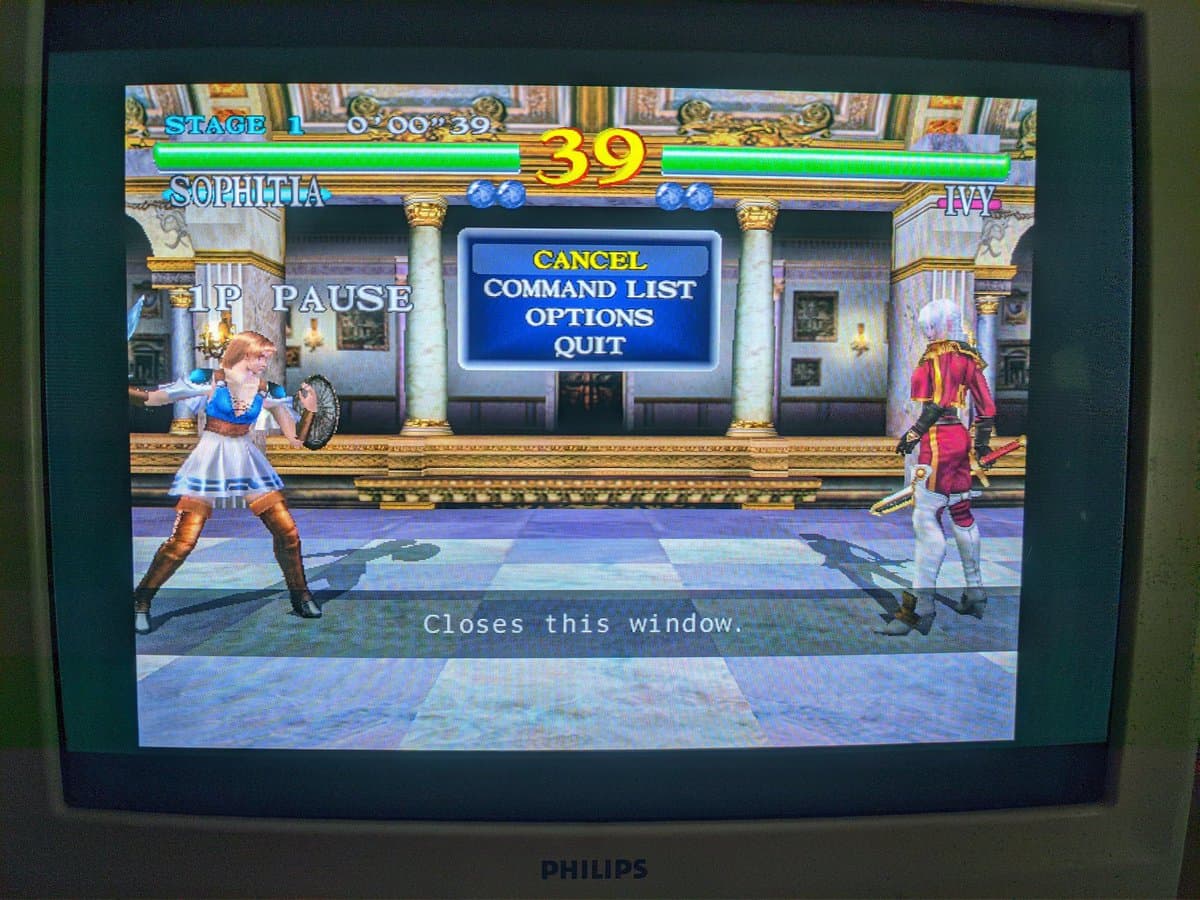 Soul Calibur arcade fighting game displaying on Philips CRT monitor, showing character Sophitia vs Ivy with pause menu overlay visible.